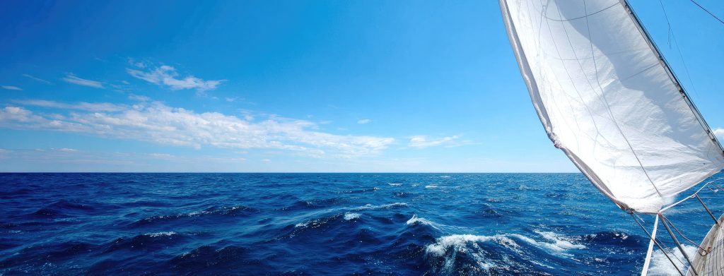 Luxury sailboat helm offers serene views in a marina on a sunny summer day, perfect for adventure and relaxation on the water