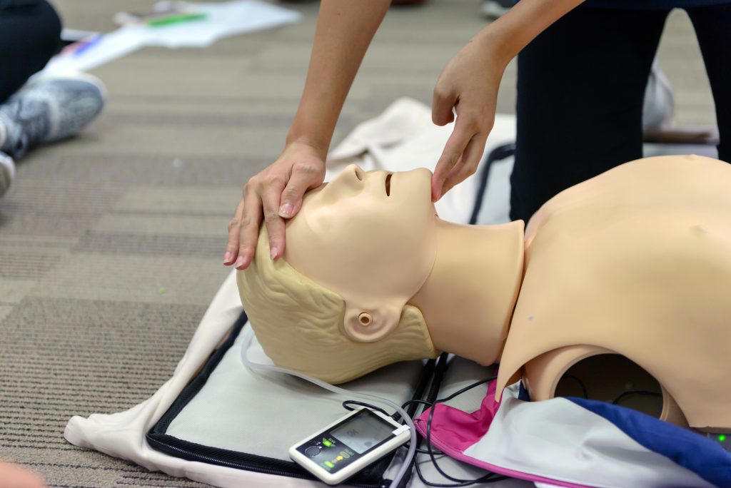 CPR First Aid Training with CPR dummy in the class