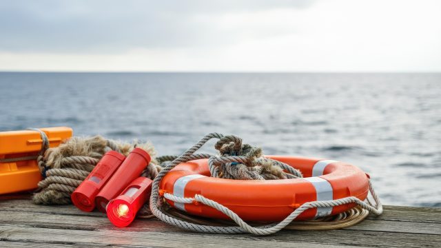 Life-saving equipment on wooden pier by sea